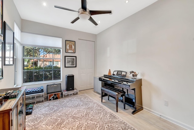 living area with ceiling fan and light hardwood / wood-style flooring