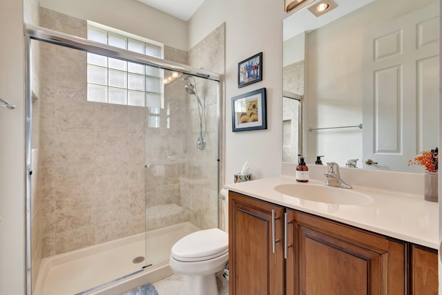 bathroom with vanity, toilet, and a shower with door