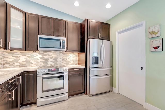 kitchen featuring stainless steel appliances, backsplash, and dark brown cabinetry