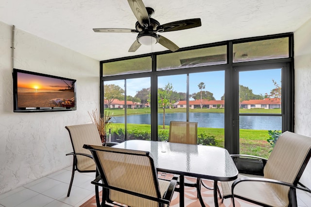 sunroom with a water view and ceiling fan