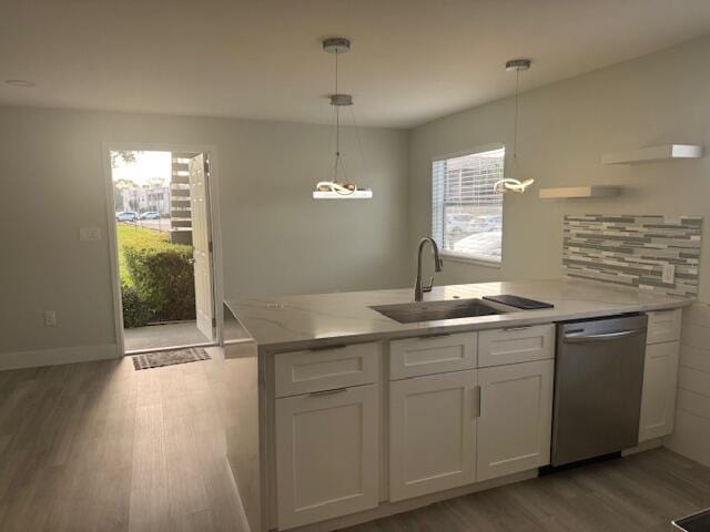 kitchen with sink, dishwasher, white cabinets, decorative light fixtures, and light wood-type flooring