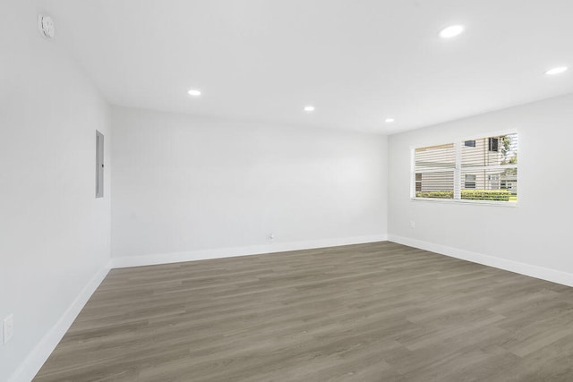 spare room with dark hardwood / wood-style flooring and electric panel