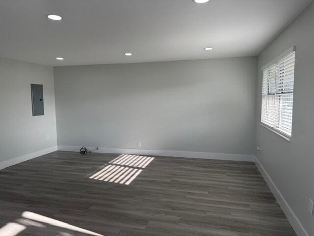 empty room featuring dark wood-type flooring and electric panel