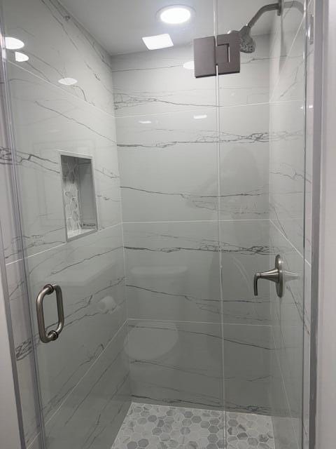 bathroom featuring a shower with shower door