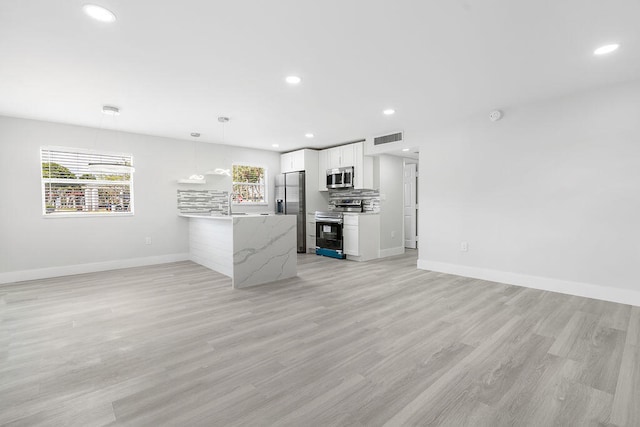 unfurnished living room featuring sink and light wood-type flooring