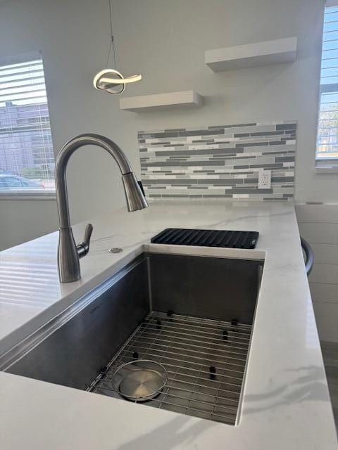 details featuring pendant lighting, sink, and decorative backsplash