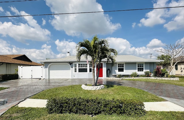 ranch-style house featuring a garage and a front lawn