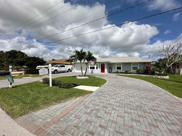 ranch-style house featuring curved driveway and a front lawn