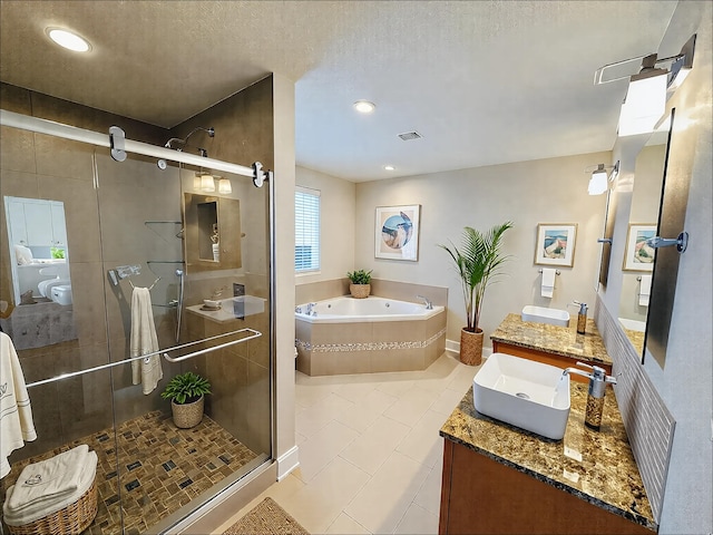 bathroom featuring a garden tub, a stall shower, tile patterned floors, vanity, and a textured ceiling