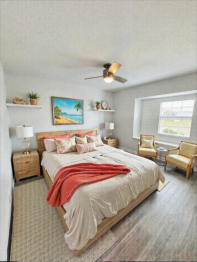 bedroom featuring ceiling fan, a textured ceiling, and wood finished floors