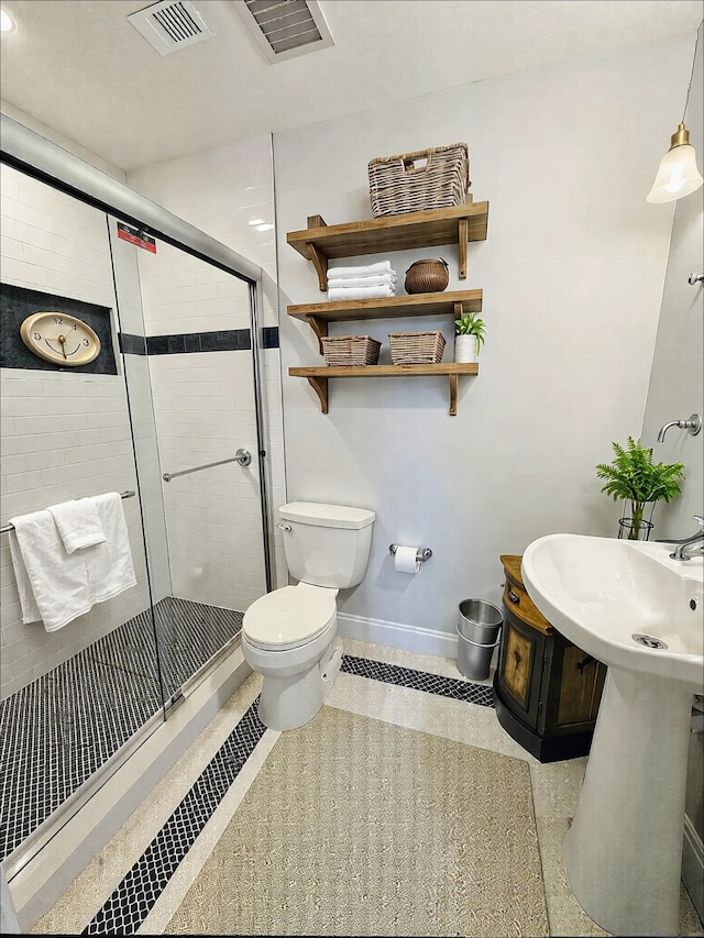 full bath featuring a shower stall, toilet, baseboards, and tile patterned flooring