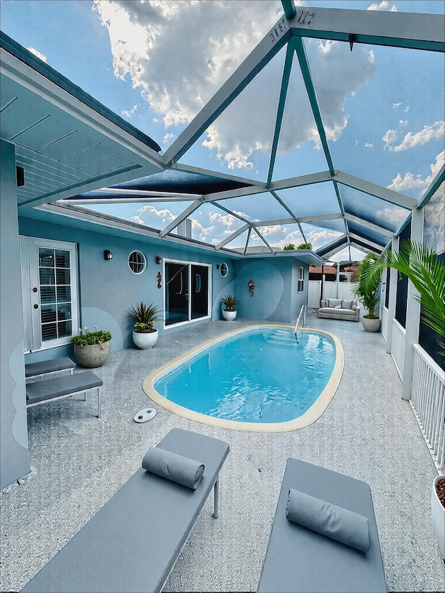outdoor pool with a patio area and glass enclosure