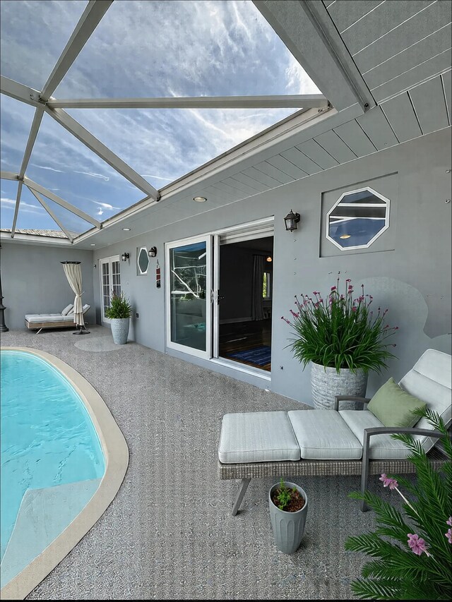 view of pool with glass enclosure and a patio area