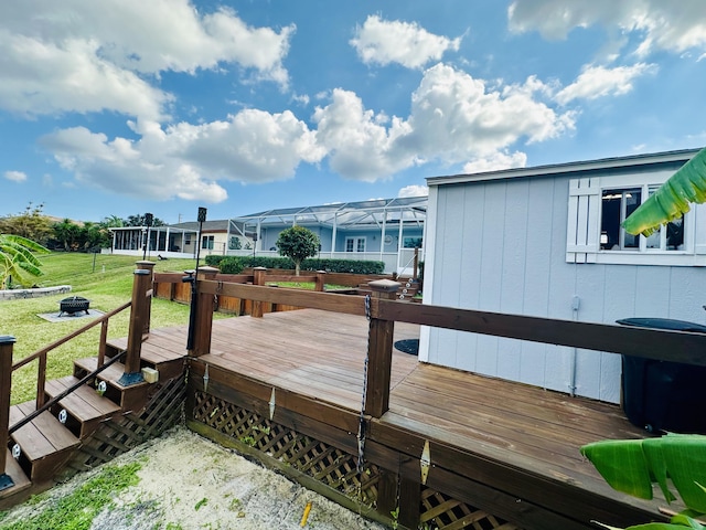 deck featuring a yard, a lanai, and a fire pit