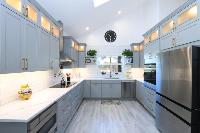4161 S US Highway 1 Unit E3, Jupiter, FL 33477 - kitchen with stainless steel appliances, decorative backsplash, light stone counters, glass insert cabinets, and high vaulted ceiling