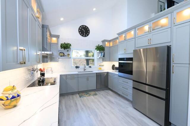 4161 S US Highway 1 Unit E3, Jupiter, FL 33477 - kitchen with appliances with stainless steel finishes, a sink, high vaulted ceiling, decorative backsplash, and open shelves