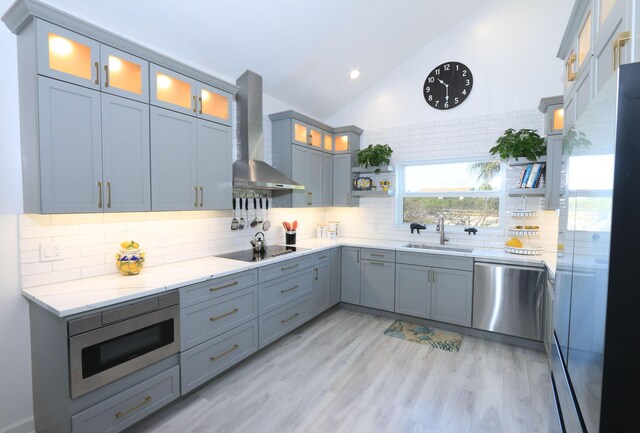 4161 S US Highway 1 Unit E3, Jupiter, FL 33477 - kitchen with appliances with stainless steel finishes, a sink, wall chimney exhaust hood, light stone counters, and backsplash