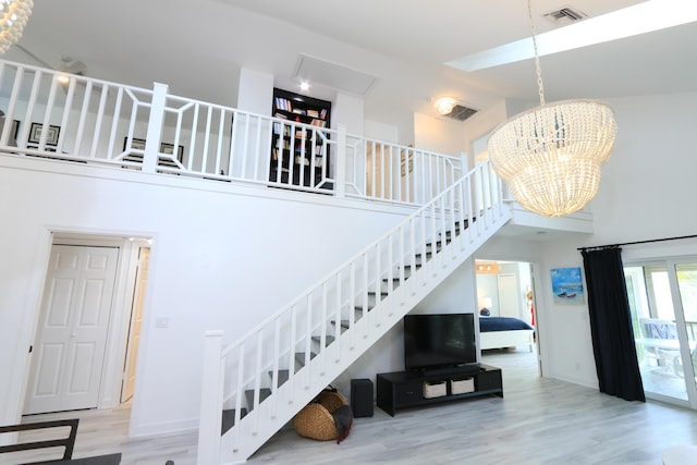 4161 S US Highway 1 Unit E3, Jupiter, FL 33477 - stairs with a towering ceiling, wood finished floors, a chandelier, and baseboards
