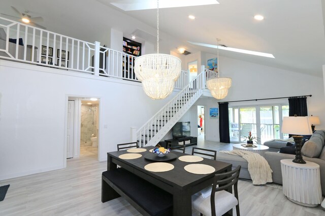 4161 S US Highway 1 Unit E3, Jupiter, FL 33477 - dining area with a skylight, high vaulted ceiling, a chandelier, stairway, and wood finished floors