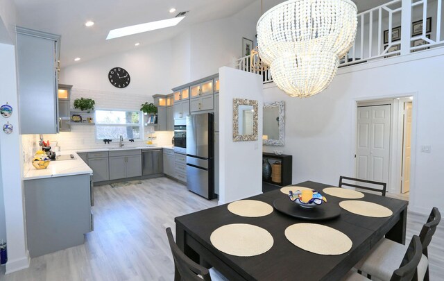 4161 S US Highway 1 Unit E3, Jupiter, FL 33477 - dining area with high vaulted ceiling, a skylight, light wood finished floors, a chandelier, and recessed lighting