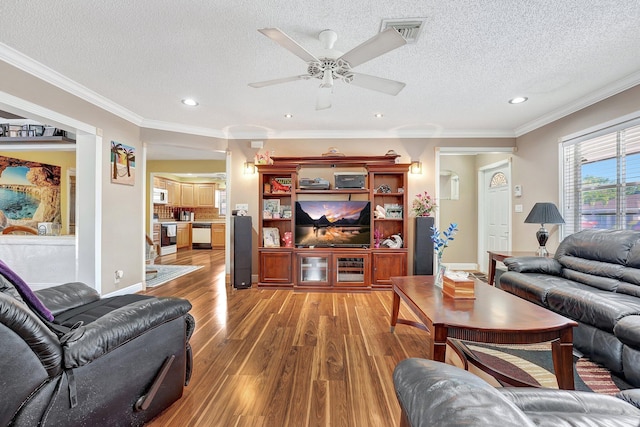 living room featuring ornamental molding, hardwood / wood-style floors, and a textured ceiling