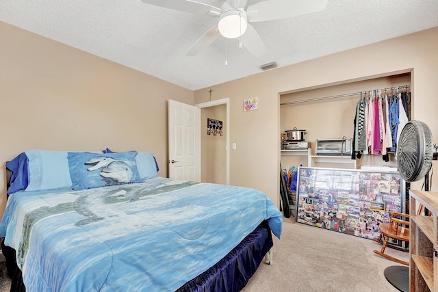 bedroom with ceiling fan, a textured ceiling, and carpet