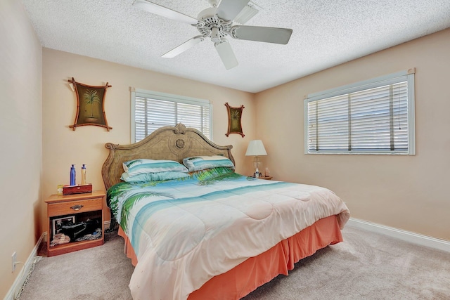 bedroom featuring ceiling fan, light colored carpet, and a textured ceiling