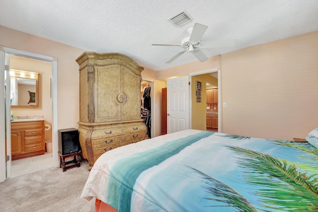 bedroom with visible vents, a textured ceiling, and ensuite bathroom