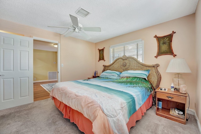 carpeted bedroom with ceiling fan and a textured ceiling