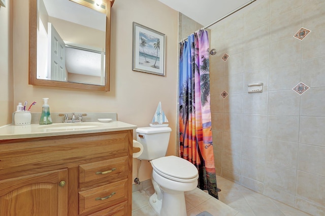 full bathroom with toilet, vanity, a tile shower, and tile patterned floors