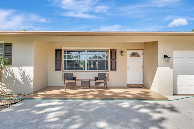 property entrance featuring an attached garage and stucco siding