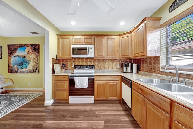 kitchen with white appliances, visible vents, wood finished floors, light countertops, and a sink