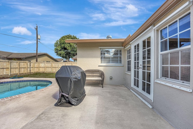 view of swimming pool featuring a fenced in pool, fence, a patio, and french doors