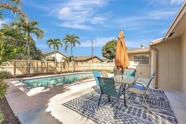 view of pool with a patio area, a fenced backyard, a fenced in pool, and outdoor dining space