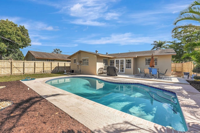 view of swimming pool with a patio, french doors, a fenced backyard, and a fenced in pool