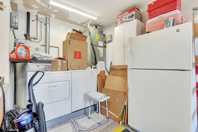 laundry room featuring a textured ceiling, laundry area, washer / dryer, and heating unit