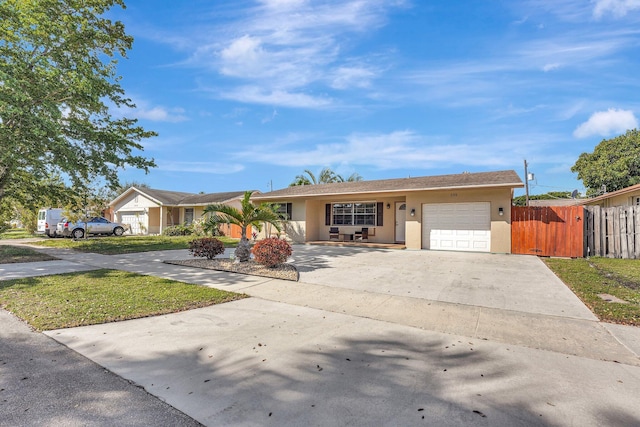 ranch-style house featuring concrete driveway, an attached garage, fence, and stucco siding