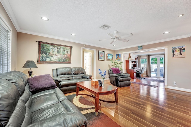 living room with french doors, a textured ceiling, ornamental molding, hardwood / wood-style flooring, and ceiling fan