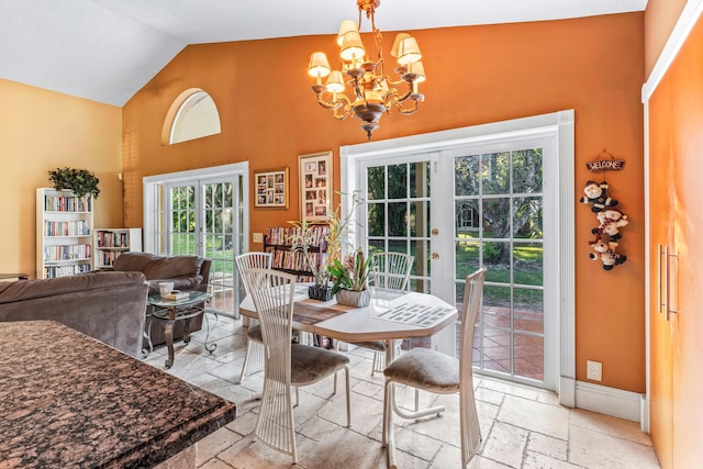 dining room featuring an inviting chandelier, high vaulted ceiling, and french doors