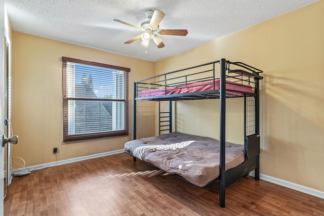 bedroom featuring hardwood / wood-style flooring, ceiling fan, and a textured ceiling