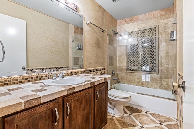 full bathroom with toilet, vanity, shower / bath combination with glass door, and tasteful backsplash