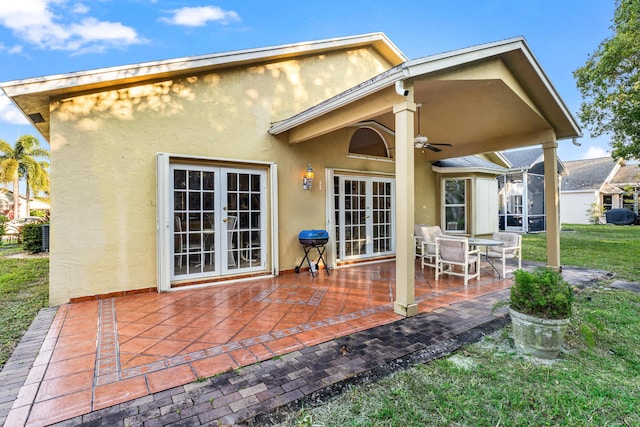 rear view of house with a patio, a yard, french doors, and ceiling fan