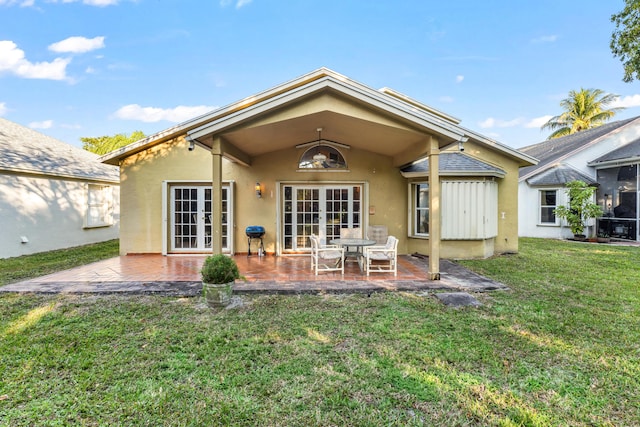 rear view of property with a yard, a patio area, and french doors