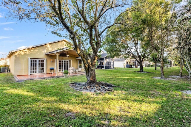 view of yard with a patio, a sunroom, cooling unit, and french doors