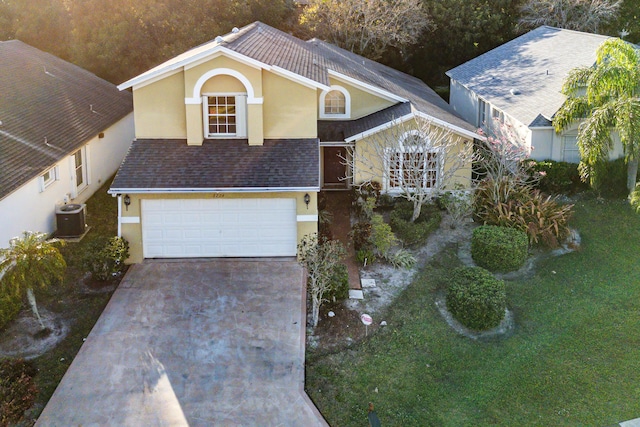 view of front of property featuring central AC, a garage, and a front yard