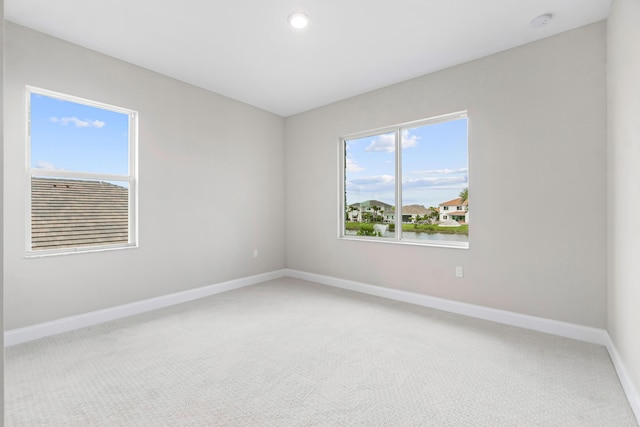 empty room featuring a water view and carpet