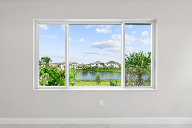 spare room featuring carpet flooring and a water view