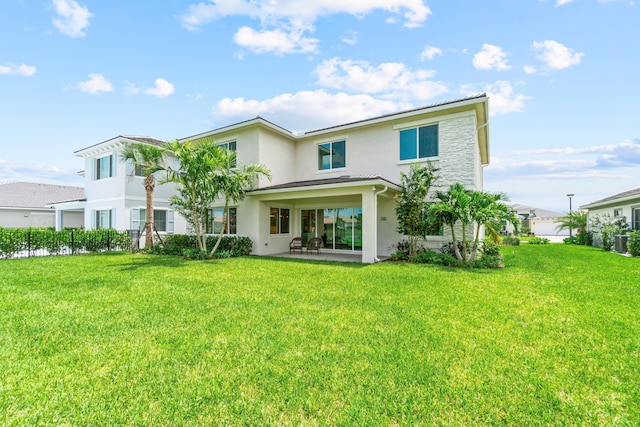 back of property featuring a yard and a patio area