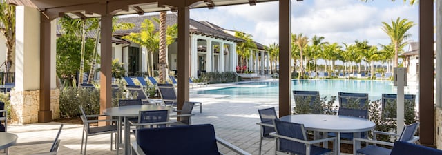 view of patio / terrace with a community pool and outdoor dining area