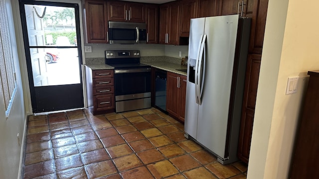 kitchen with light stone countertops and appliances with stainless steel finishes